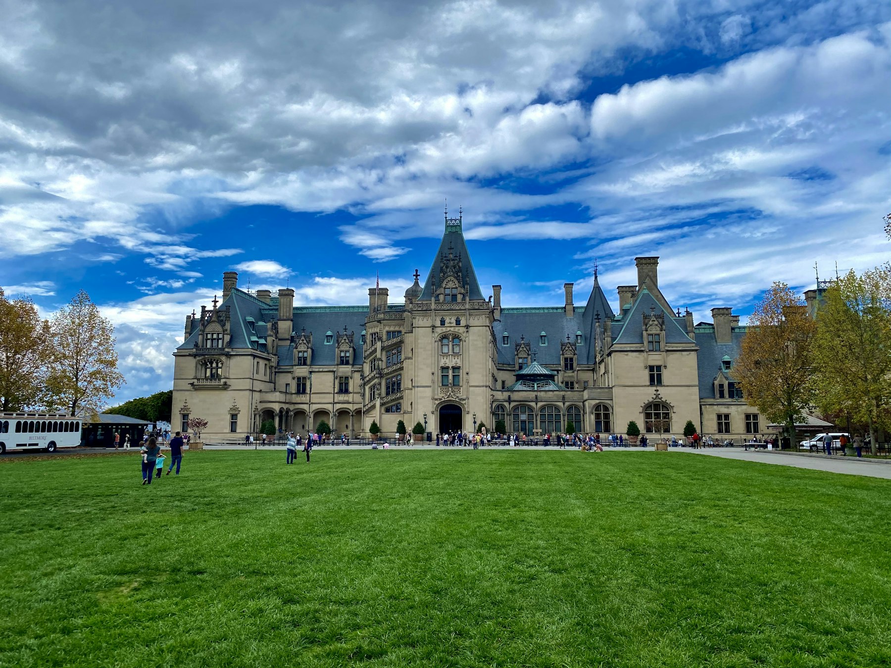The Biltmore House in Asheville North Carolina seen across its wide green lawn under a dramatic sky