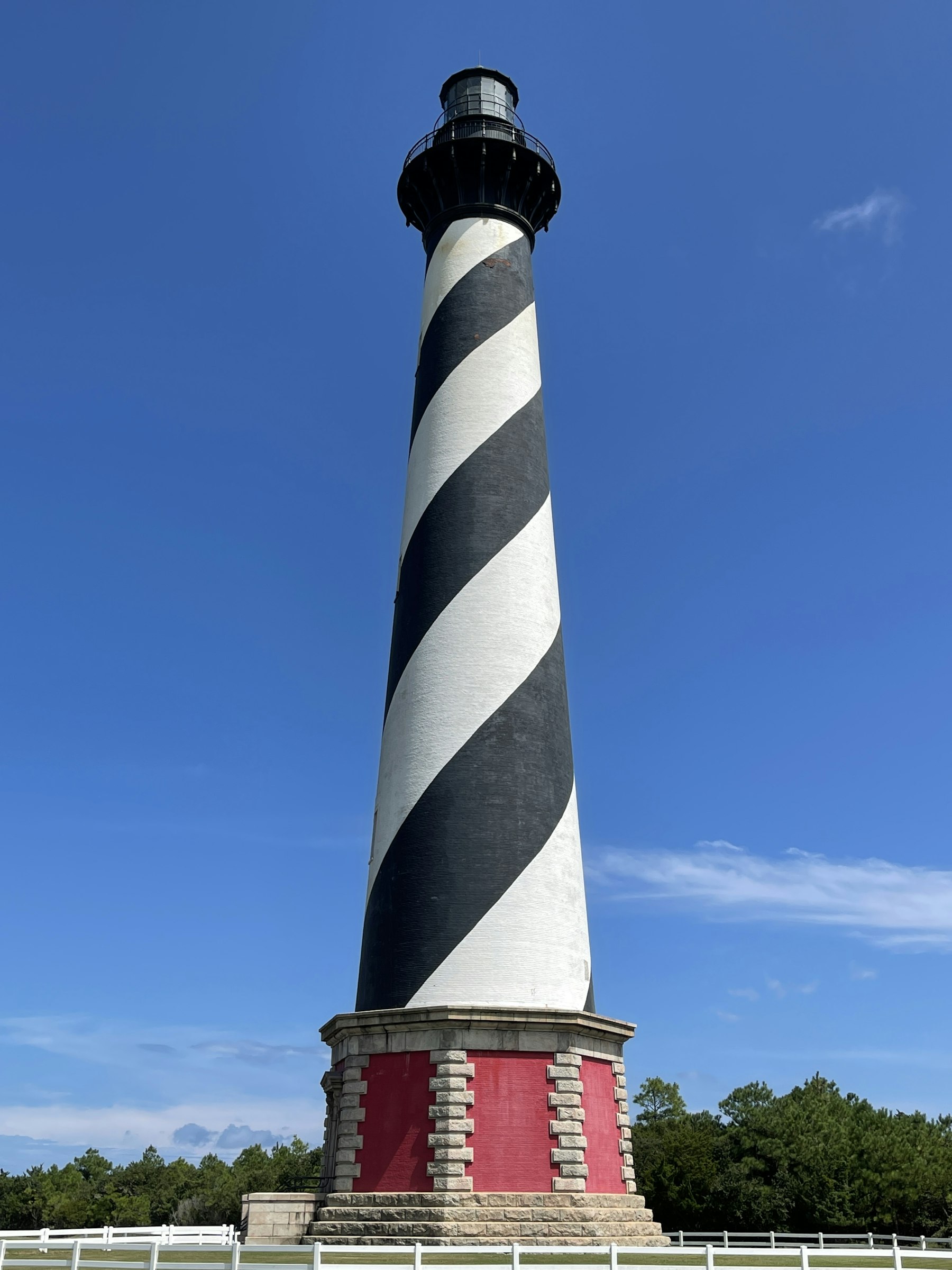 The black and white spiral striped Cape Hatteras Lighthouse against a deep blue sky
