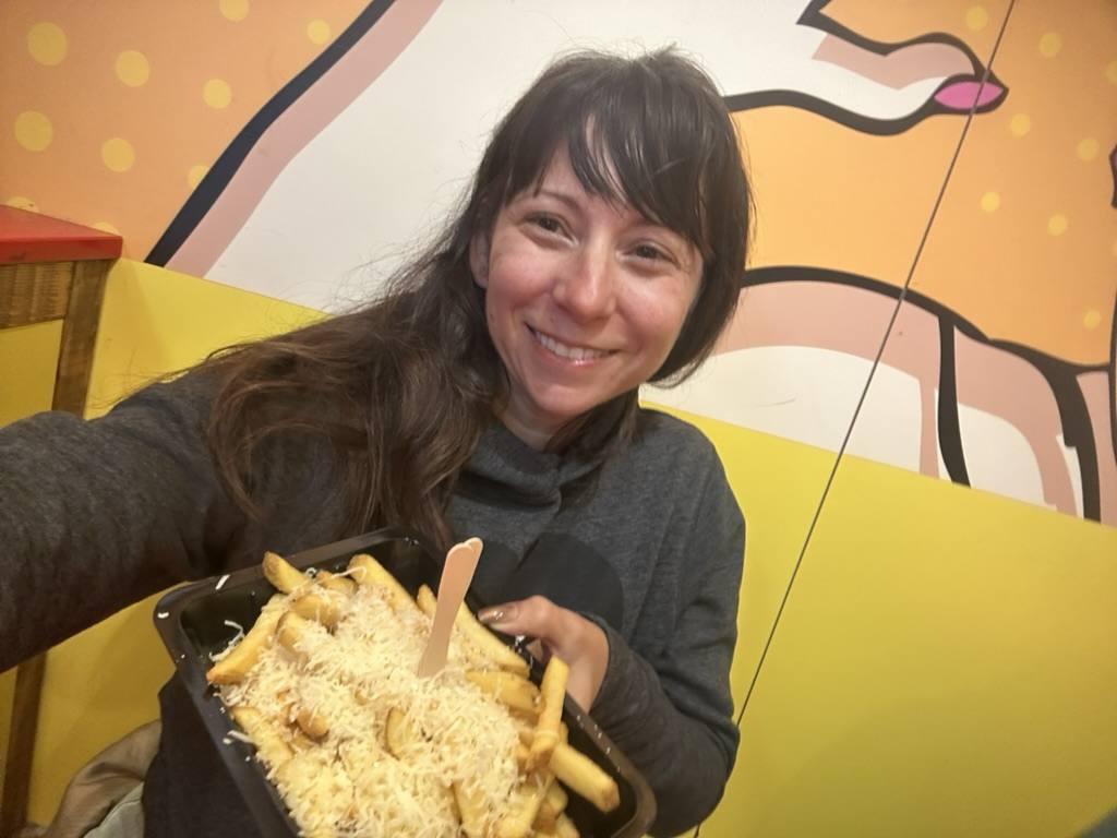 Nicole holding a tray of thick Dutch fries topped with a heavy swirl of mayonnaise