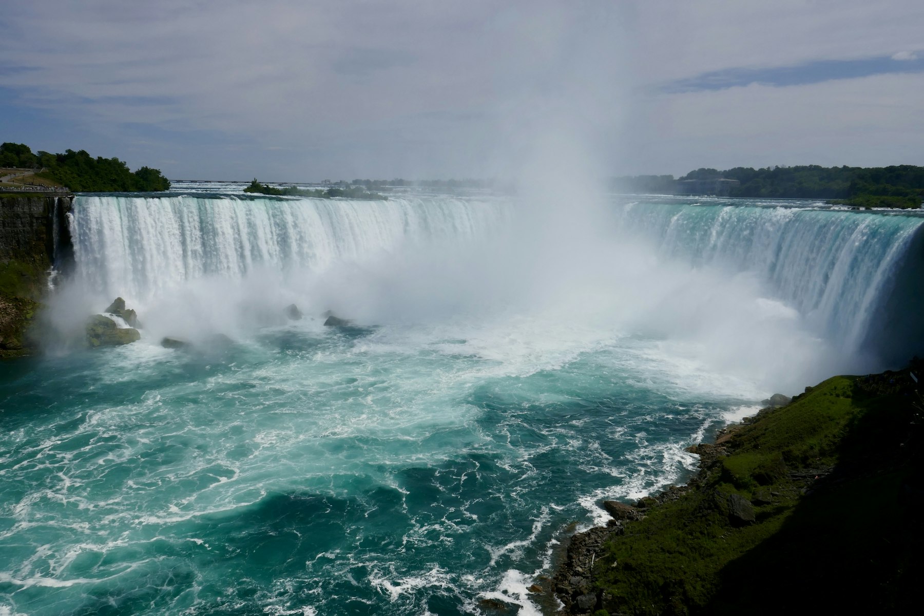 The full curve of the Horseshoe Falls at Niagara with mist rising from the gorge
