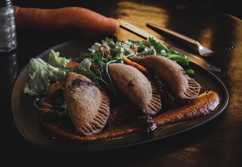 Fried stuffed pastries served on a dark plate
