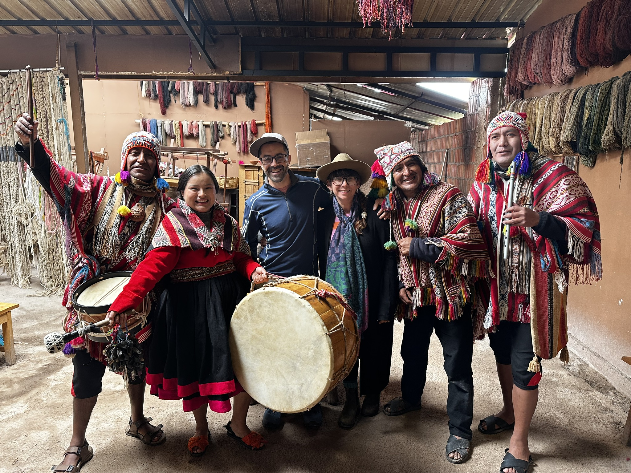 Weavers and musicians in traditional Andean dress at a weaving cooperative in Chinchero Peru