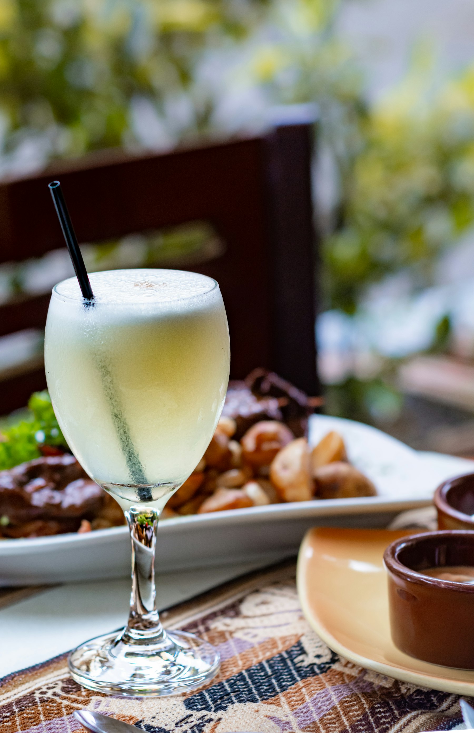 A pisco sour cocktail with a thick foam top in a glass
