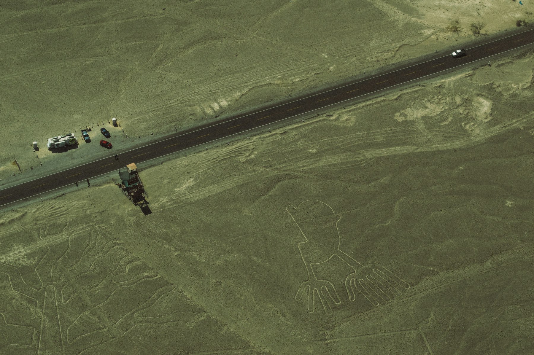 An aerial view of the Nazca desert in Peru with ancient geoglyph lines crossed by the highway