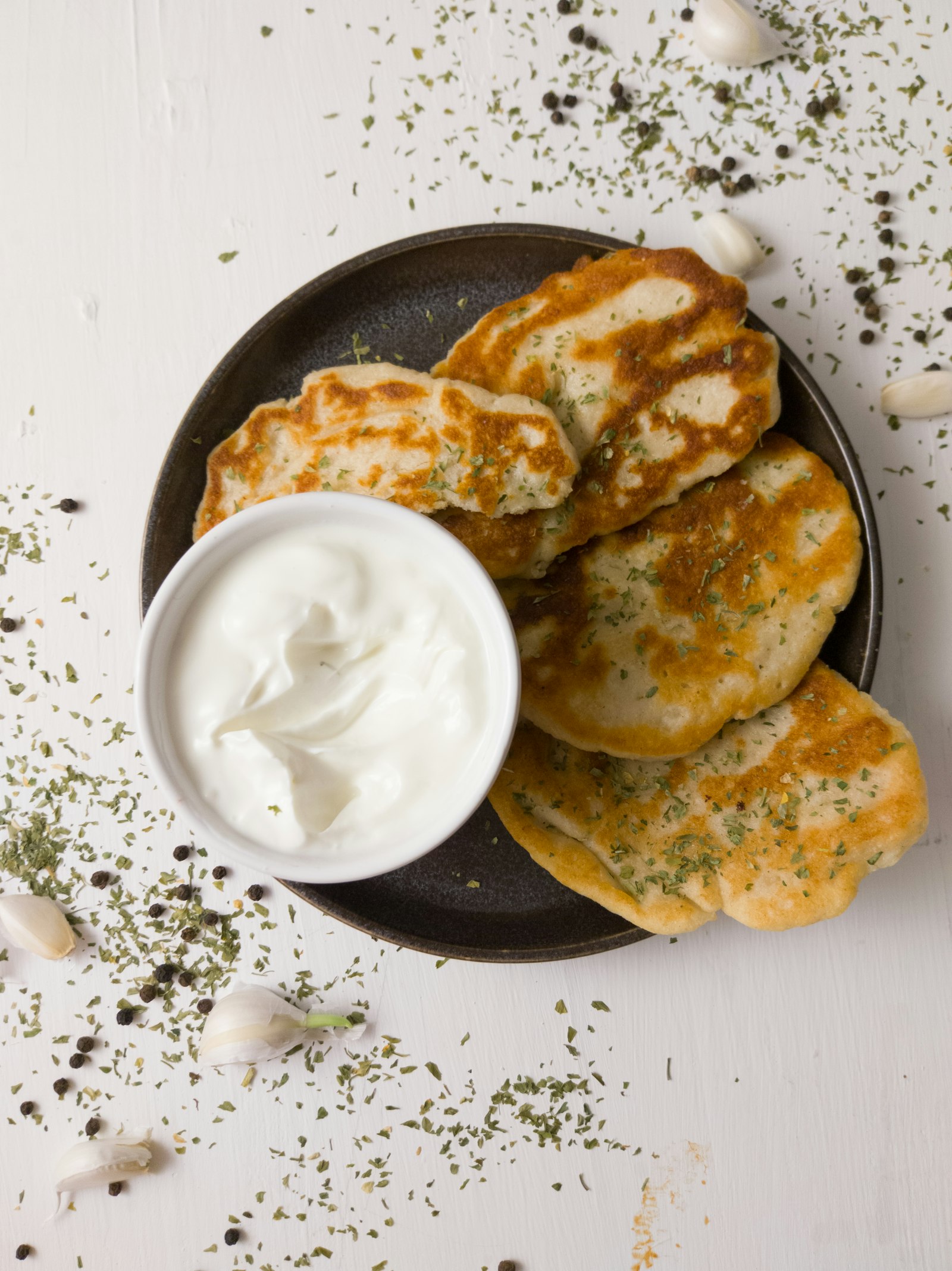 Golden fried potato pancakes served with a bowl of sour cream