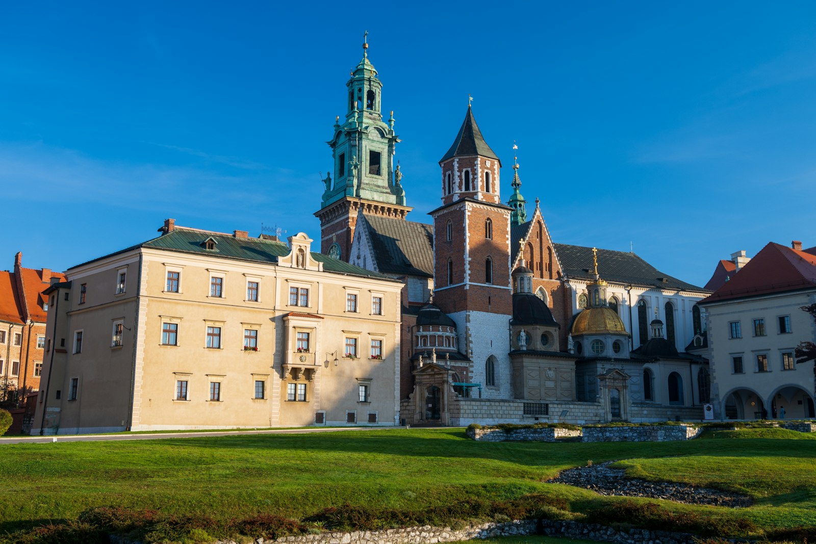 Wawel Royal Castle and cathedral in Krakow in low golden light above green lawns