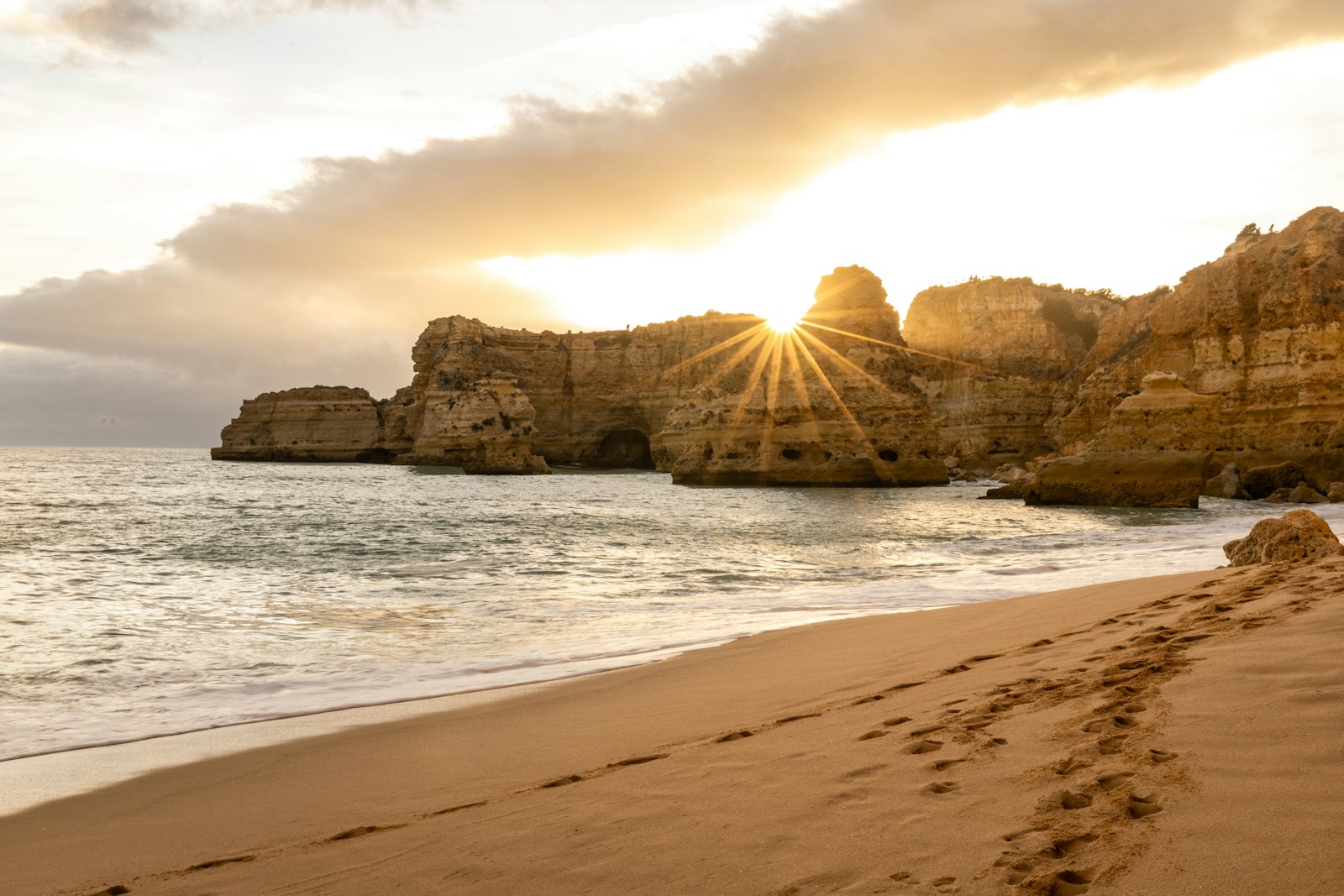 Golden cliffs and a wide sand beach on the Algarve coast at sunset