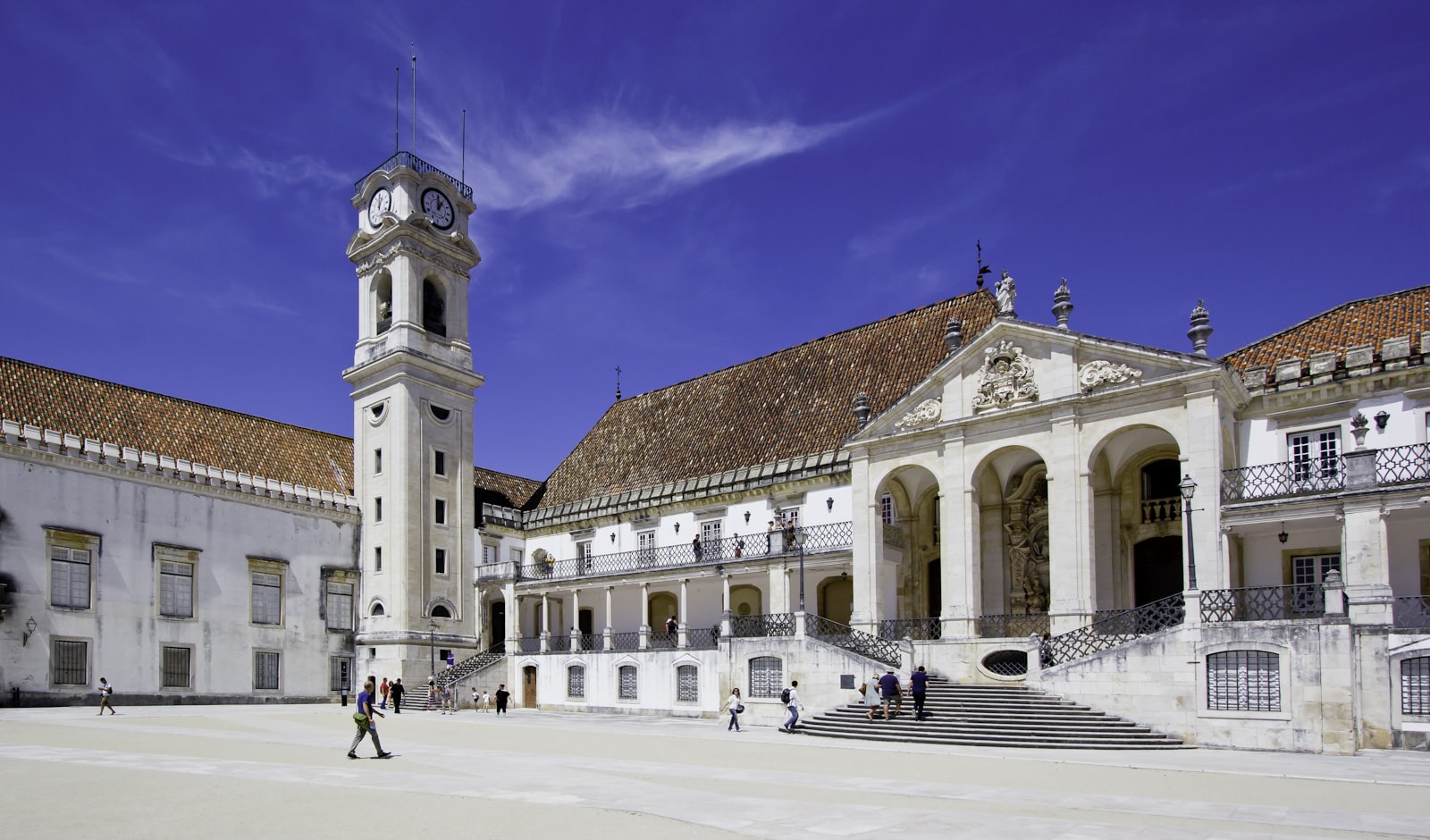 The old university courtyard and clock tower at Coimbra under a blue sky