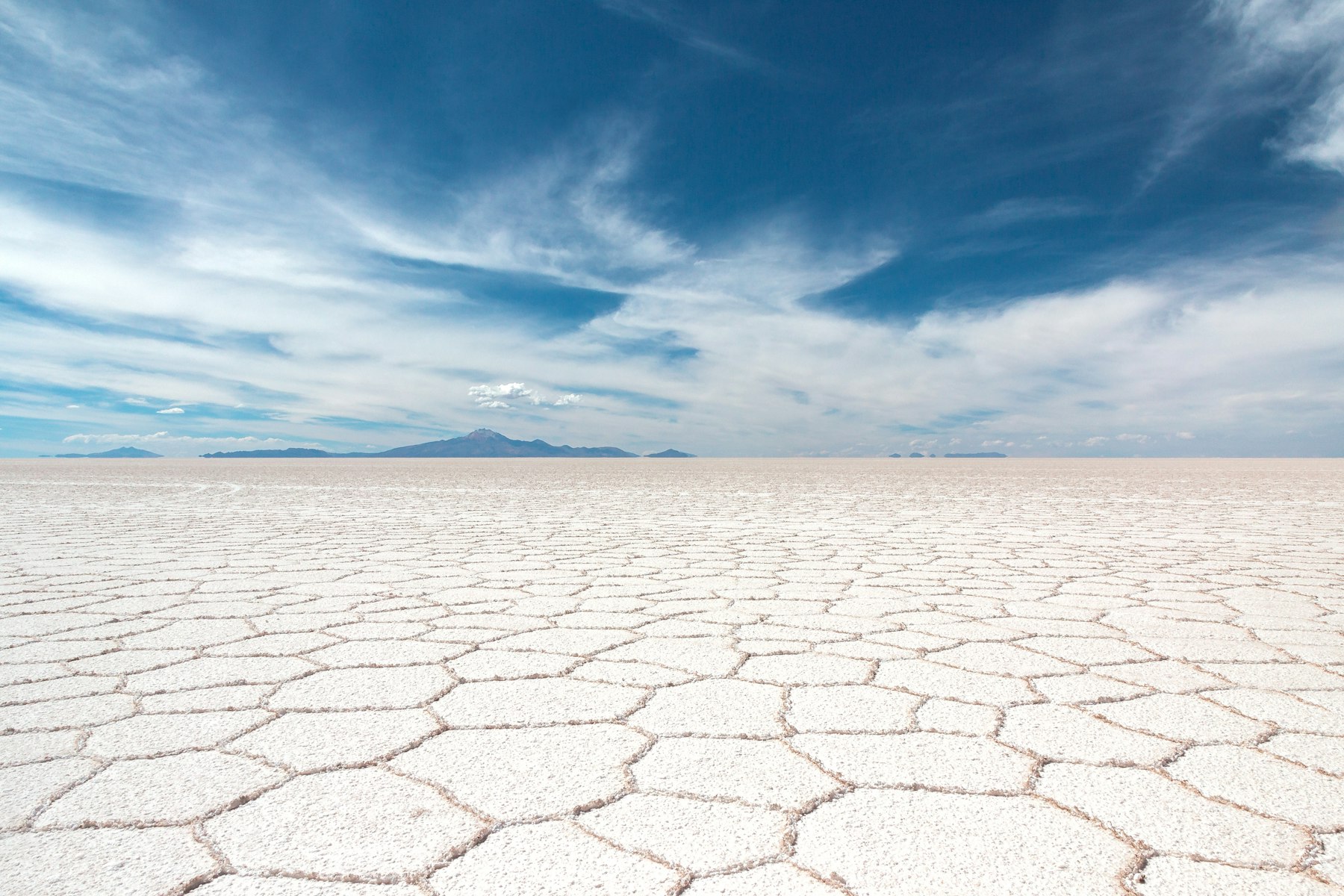 The hexagonal salt crust of the Salar de Uyuni stretching to the horizon in Bolivia