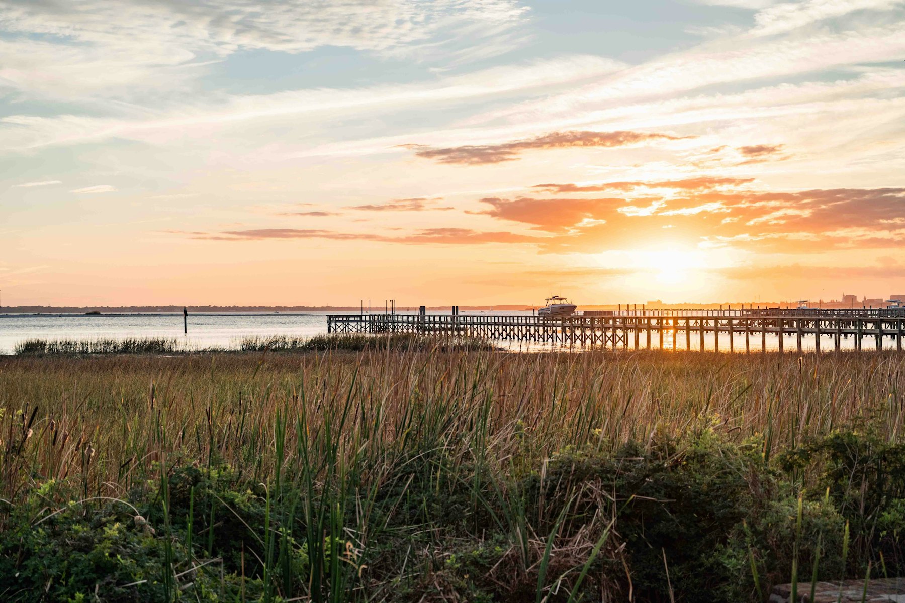 The sun setting over the salt marsh and a fishing pier on the South Carolina coast