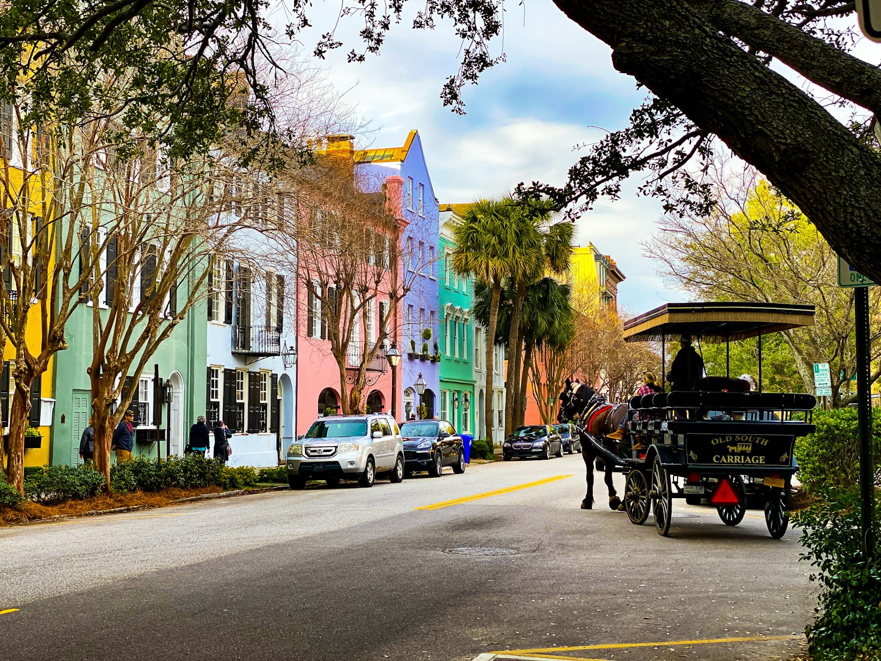 A horse drawn carriage passing the pastel houses of Rainbow Row in Charleston South Carolina