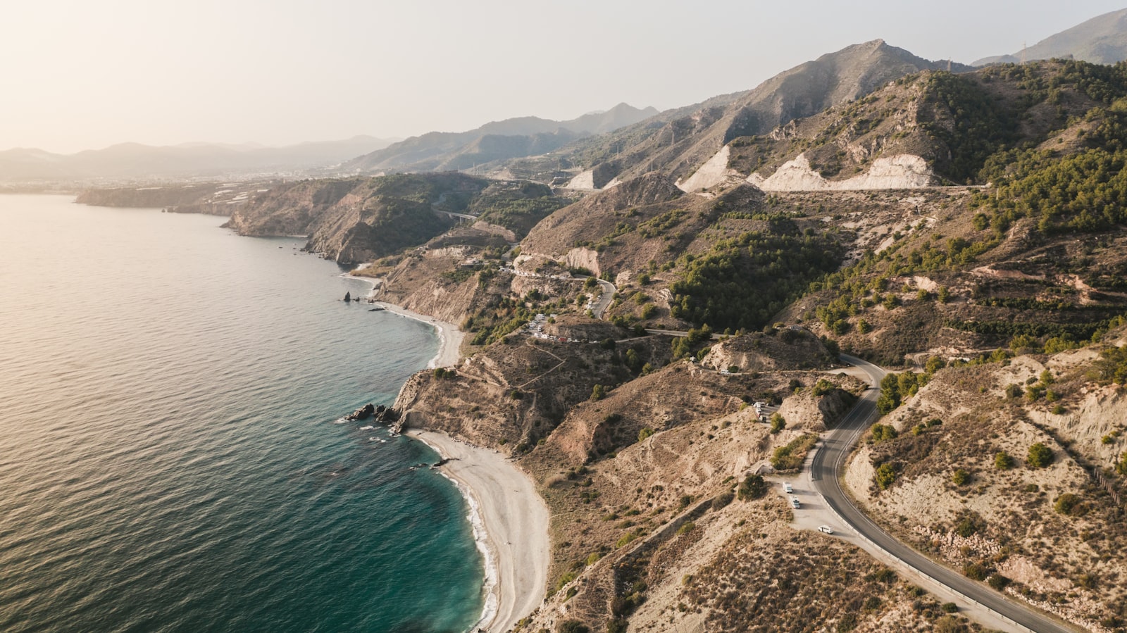 A road winding along the cliffs above a blue Mediterranean bay in Spain