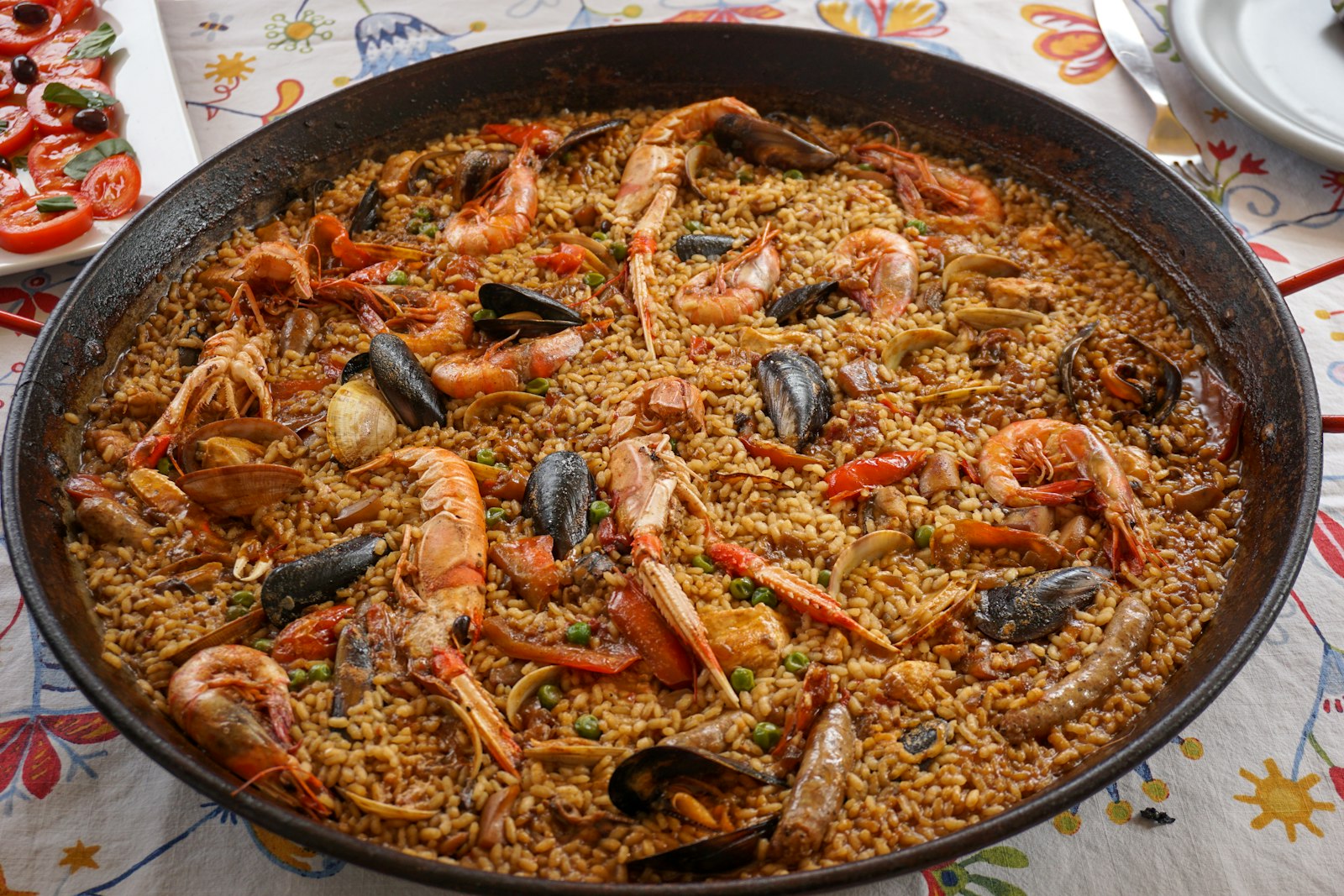 A wide pan of seafood paella with prawns and mussels