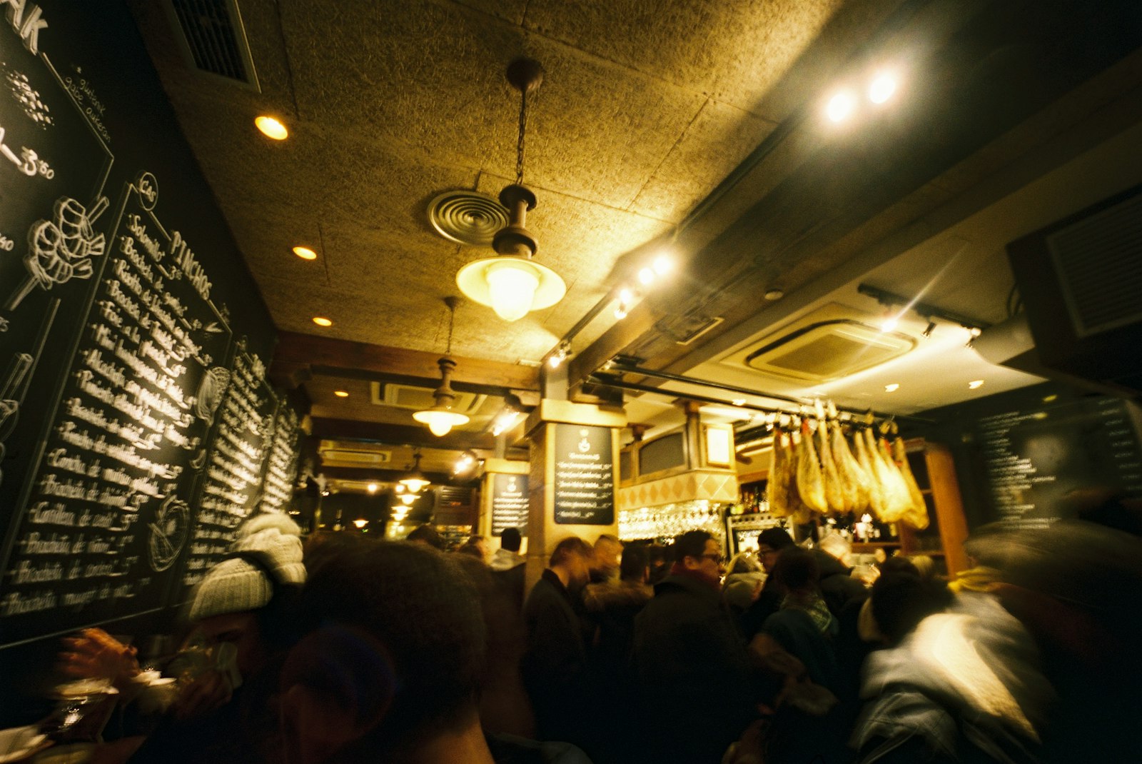 The crowded wooden bar of a traditional Spanish tapas bar