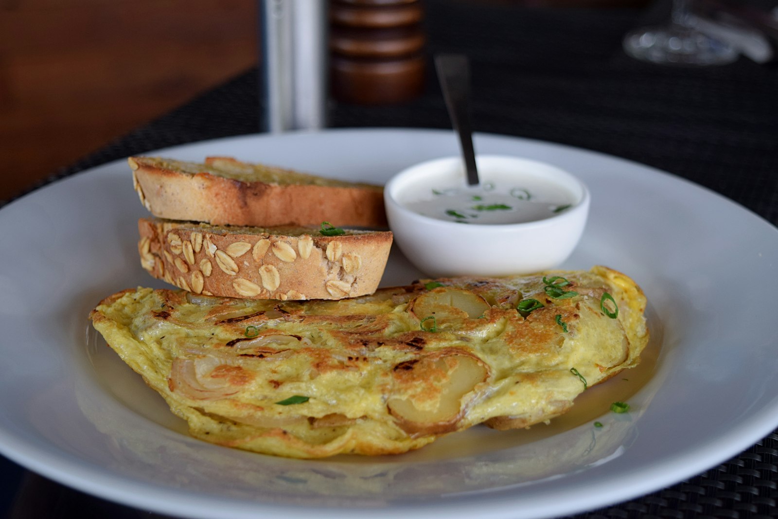 A slice of tortilla espanola with bread on a plate in Spain