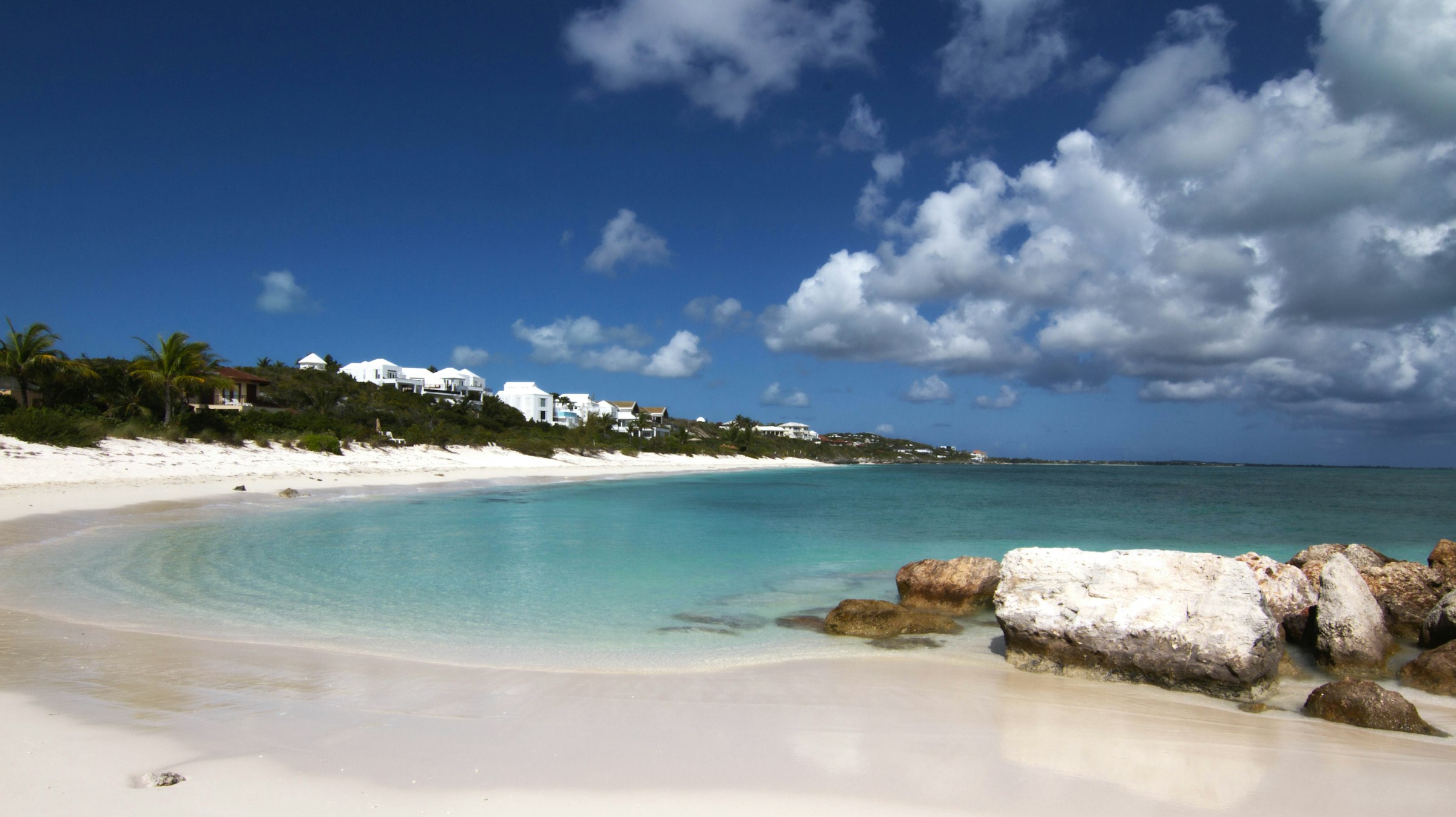 A wide white sand beach and pale turquoise water in the Turks and Caicos Islands