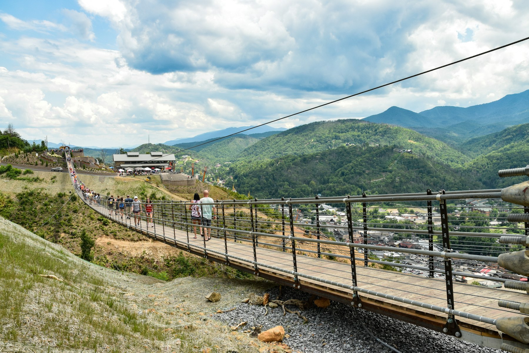 People crossing a long suspension footbridge above a valley near Gatlinburg Tennessee
