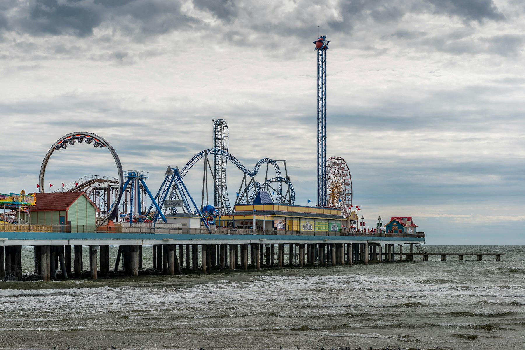 A ferris wheel and fairground rides on the pier at Galveston Texas