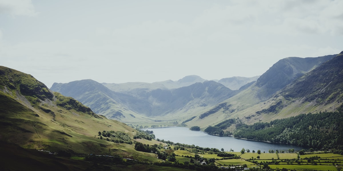 A long lake in the Lake District held between green fells under a soft sky
