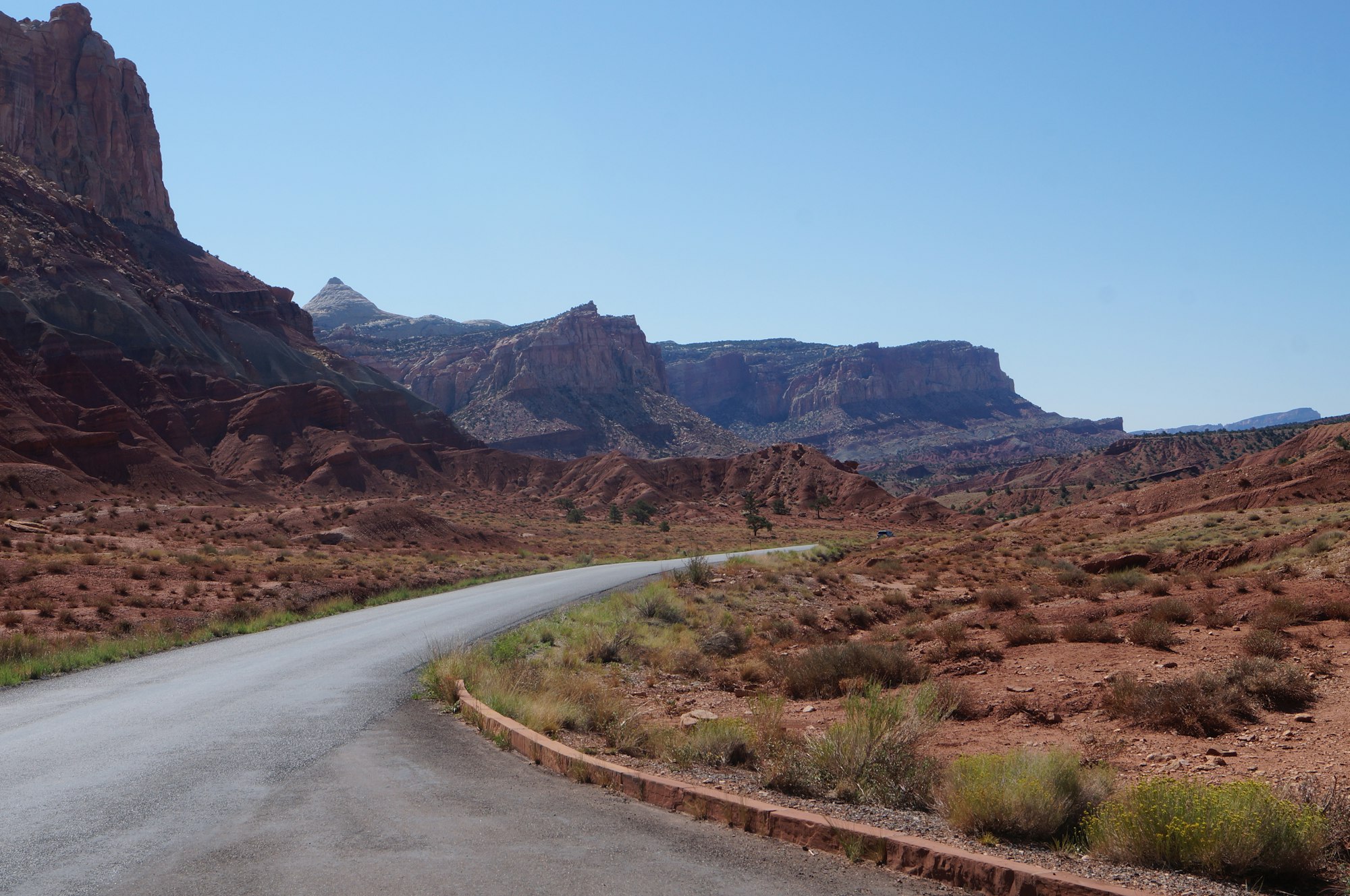 An empty desert highway curving through Utah slickrock country