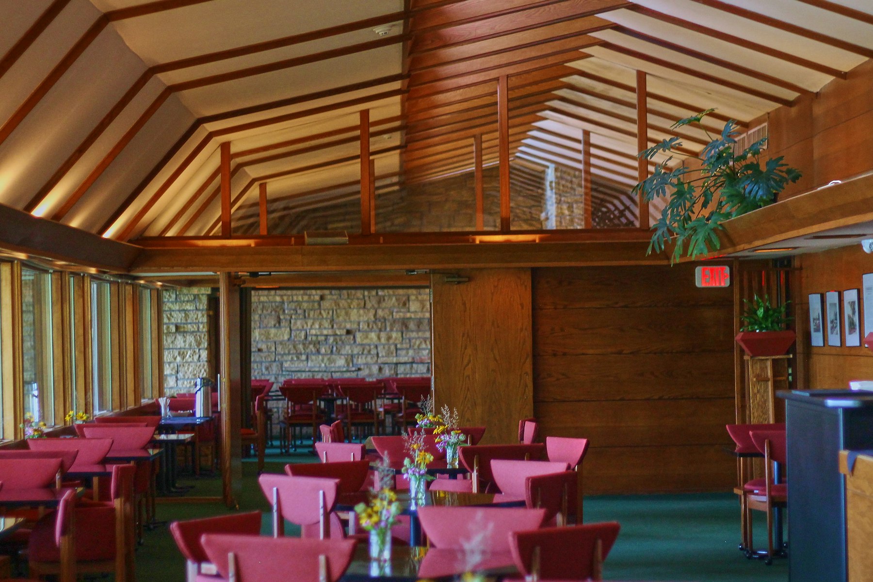 A national park lodge dining room with heavy timber beams and red chairs