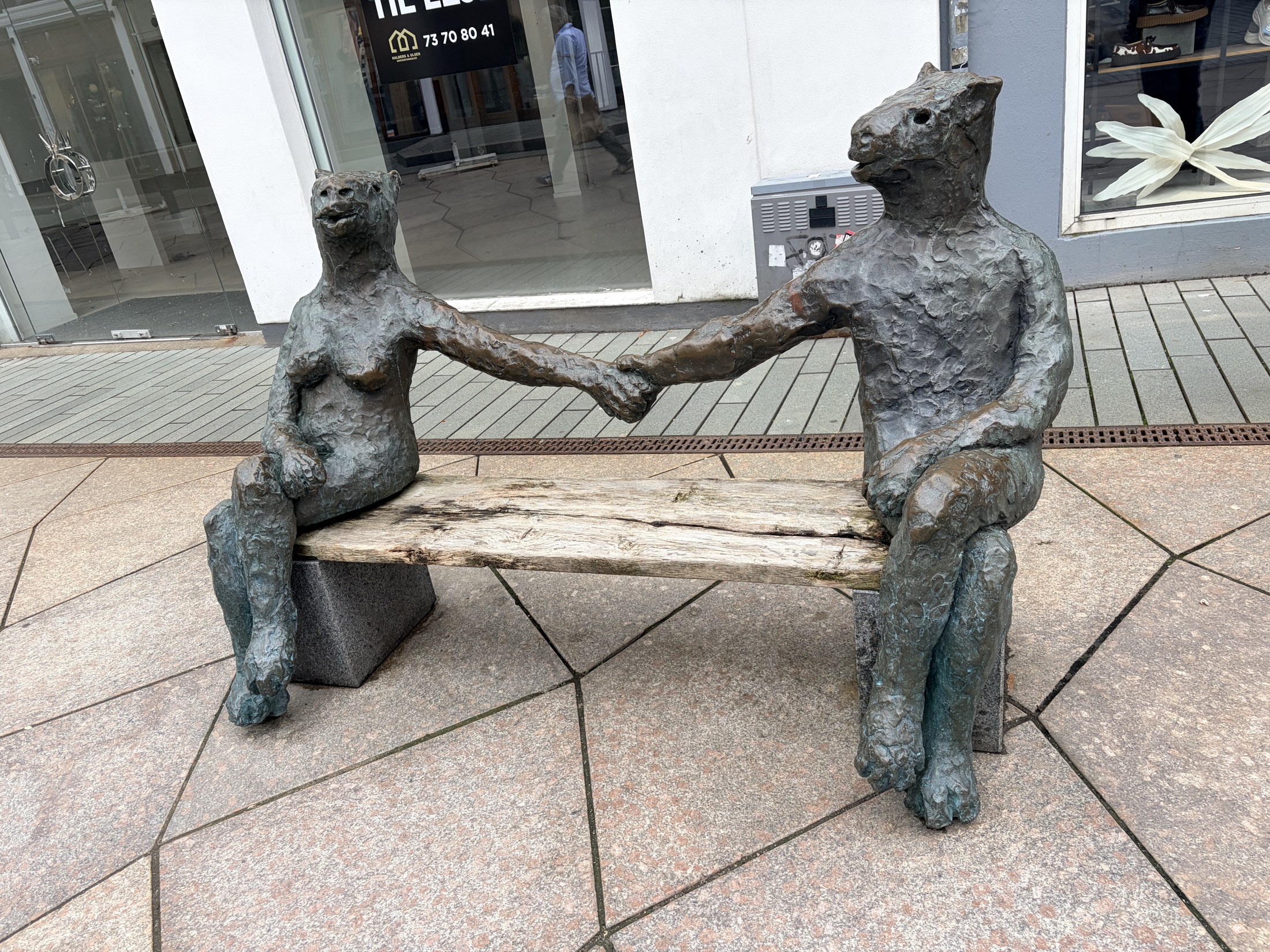 Two bronze figures sitting on a bench
